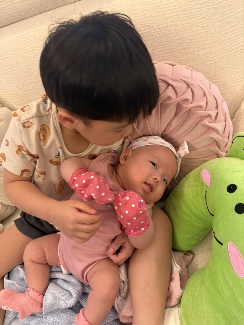 Big brother watching over his baby sister