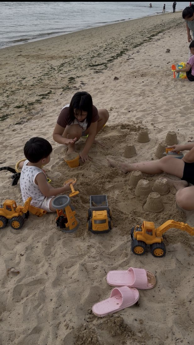 Helper building sandcastles with children